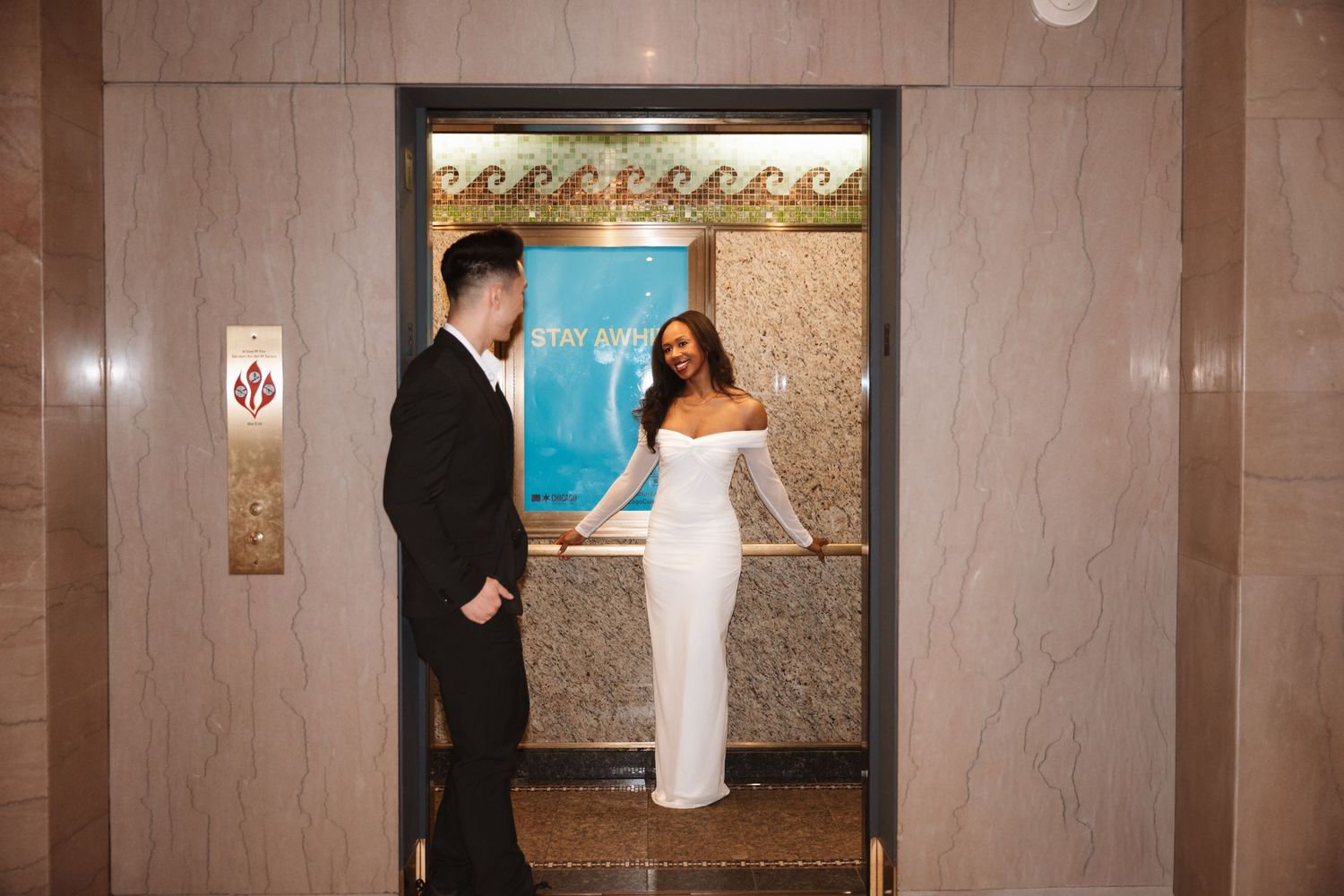 Couple sharing a tender moment inside a decorated elevator, bride in white off-shoulder dress and groom in black suit.Chicago Wedding Photog