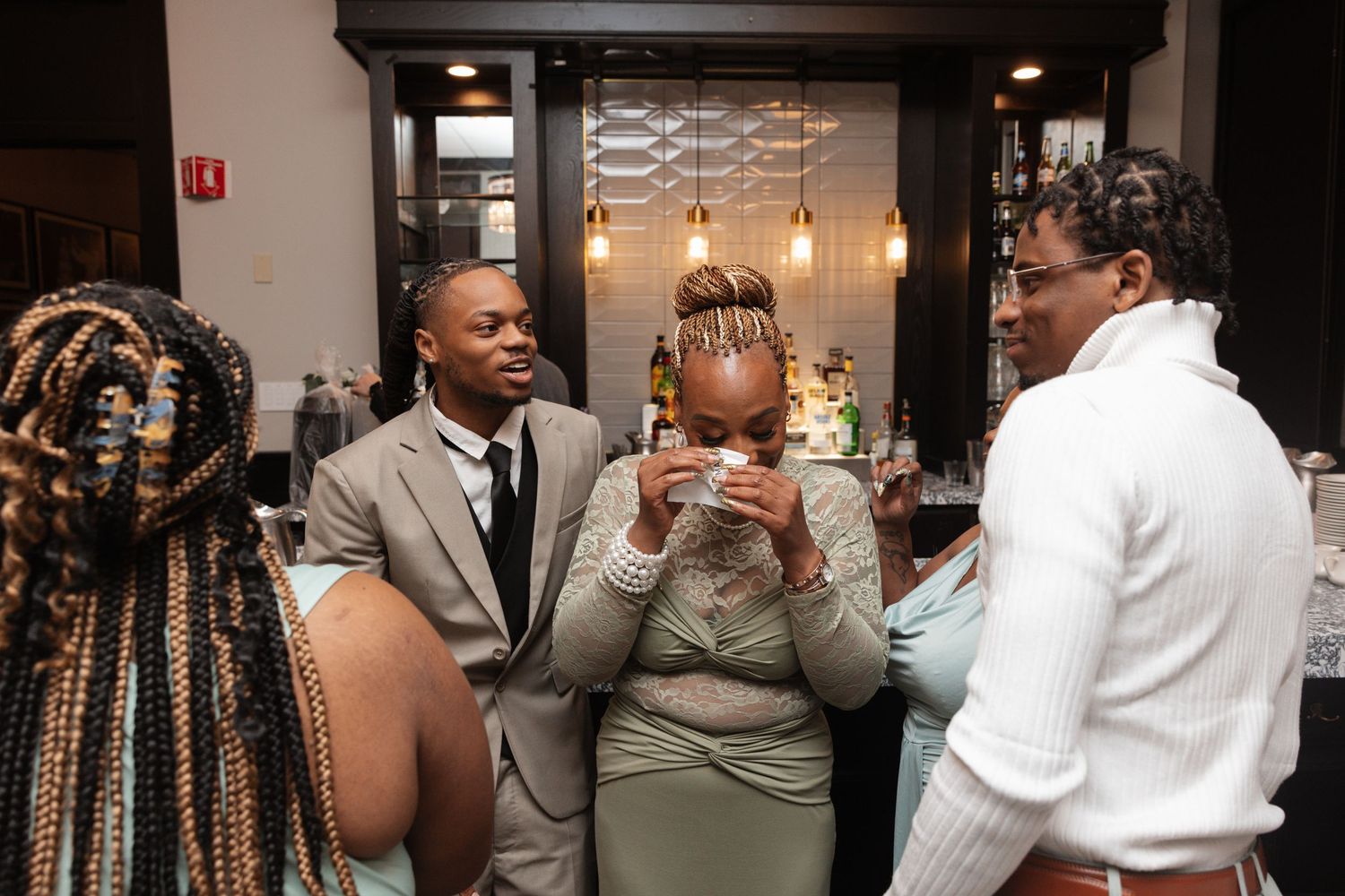 Wedding guests socializing and laughing together at indoor reception venue.