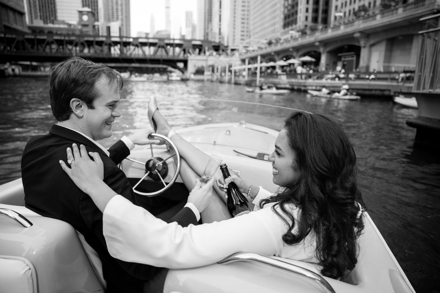 Couple sharing a romantic moment on a vintage boat along the Chicago River in black and white.