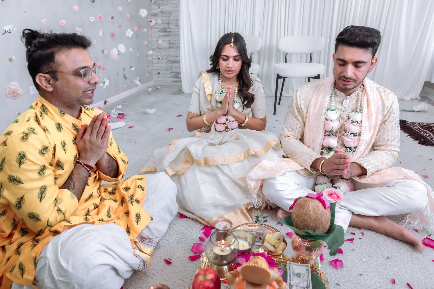 Hindu wedding ceremony with priest and couple performing traditional rituals with sacred offerings.