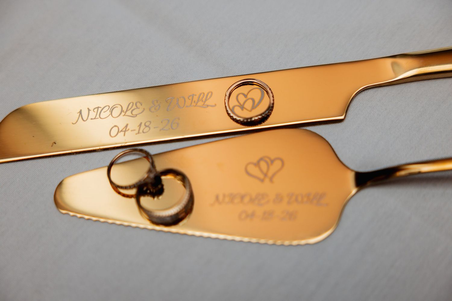 Gold engraved wedding cake cutting set personalized with couple names Nicole and David and wedding date.