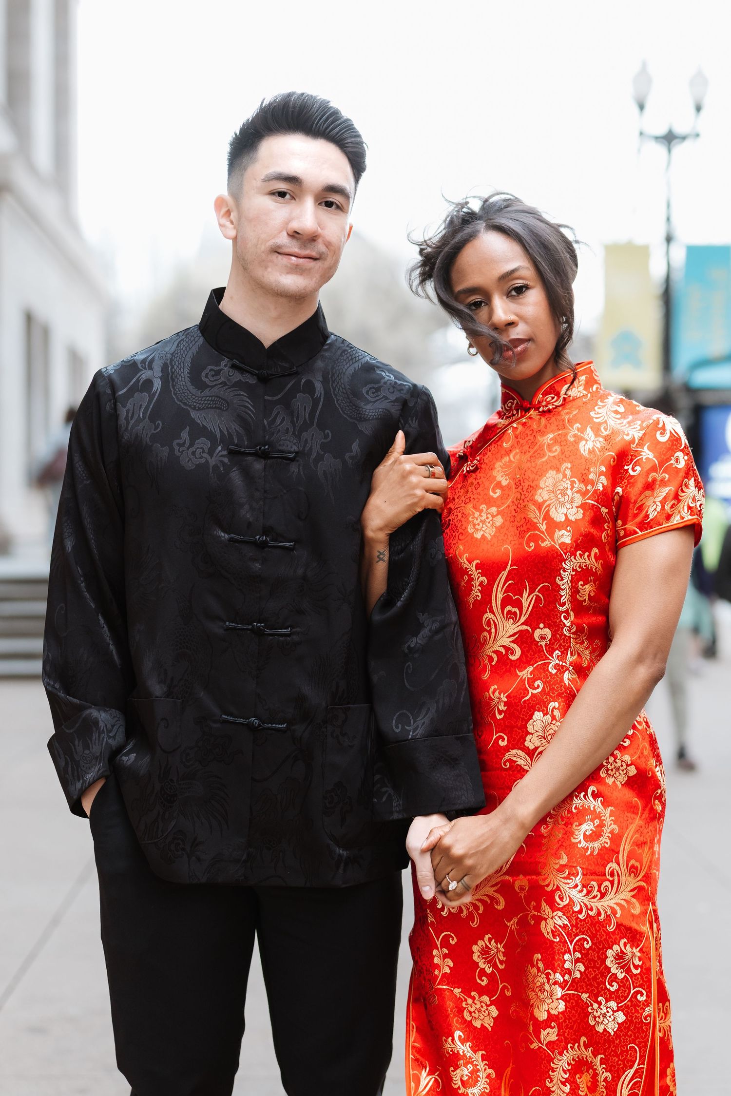 Interracial couple posing in traditional Chinese attire on an urban street, woman in red qipao.
Chicago Wedding Photographer