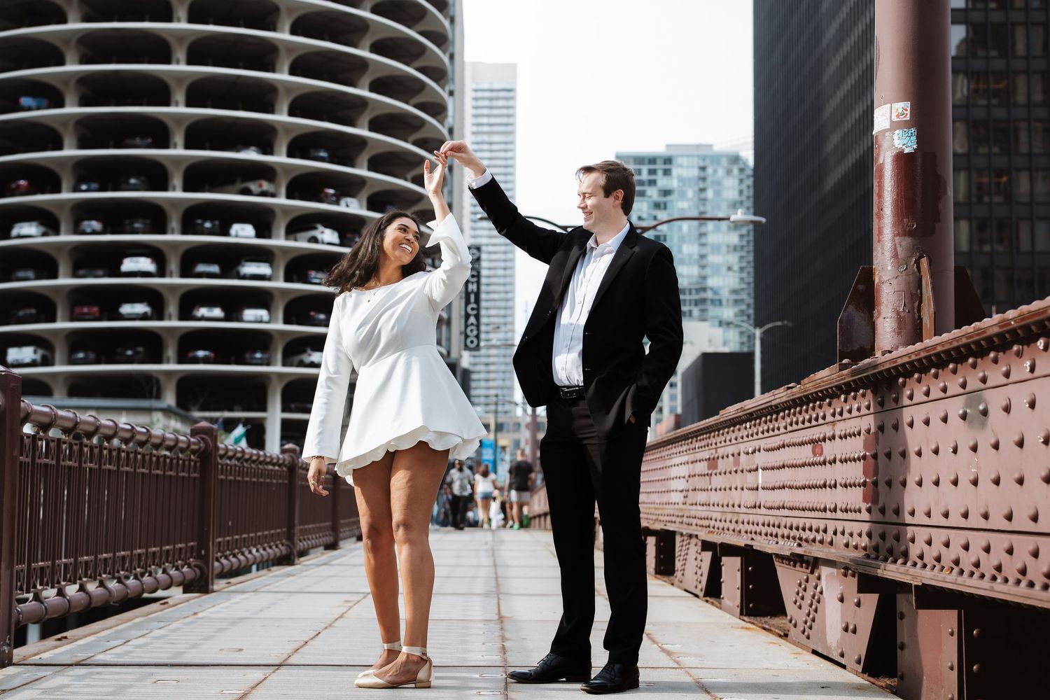 Couple dancing on a bridge with Chicago Marina City towers in the background during engagement shoot.