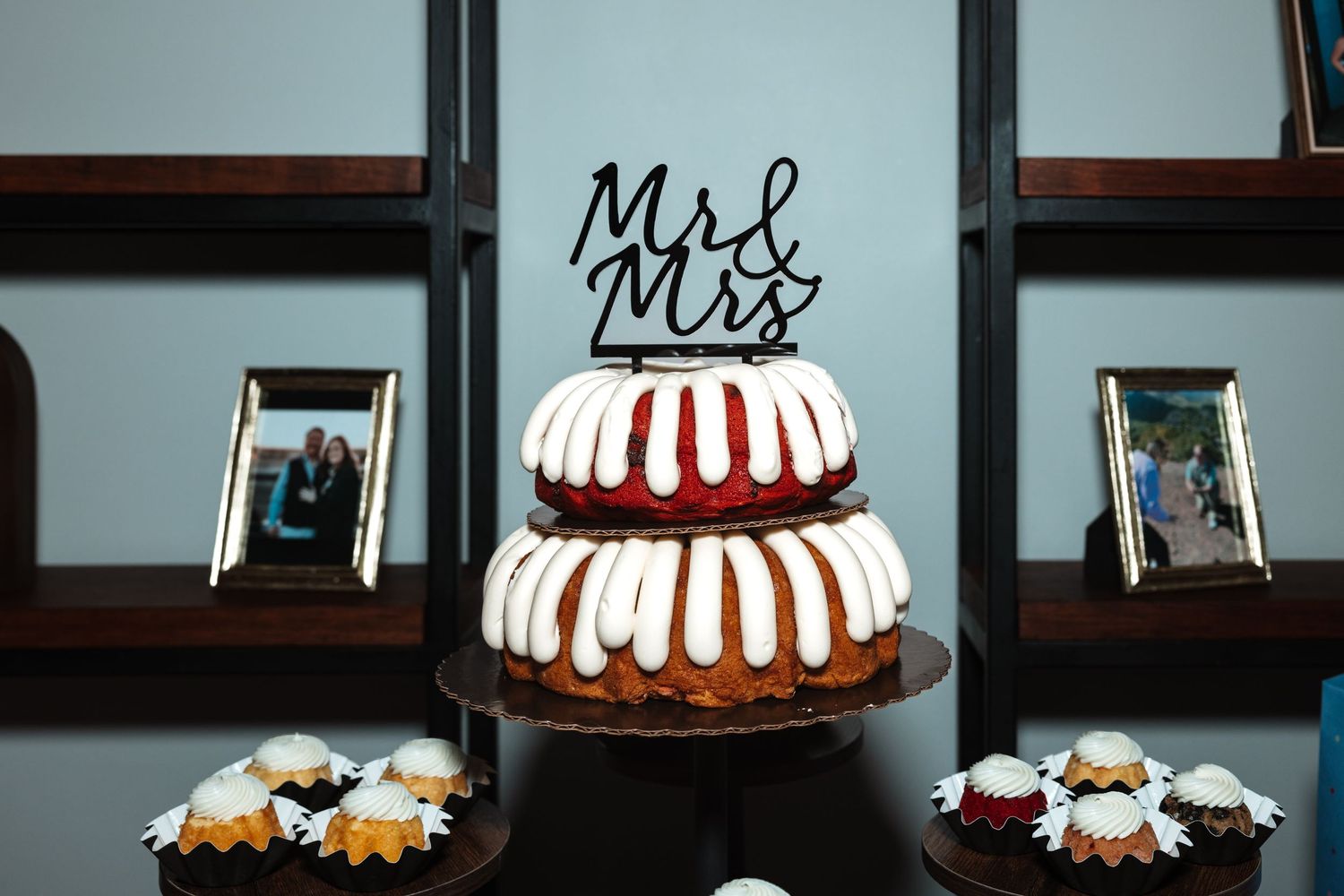 Two-tier wedding bundt cake with Mr and Mrs topper surrounded by mini cakes.