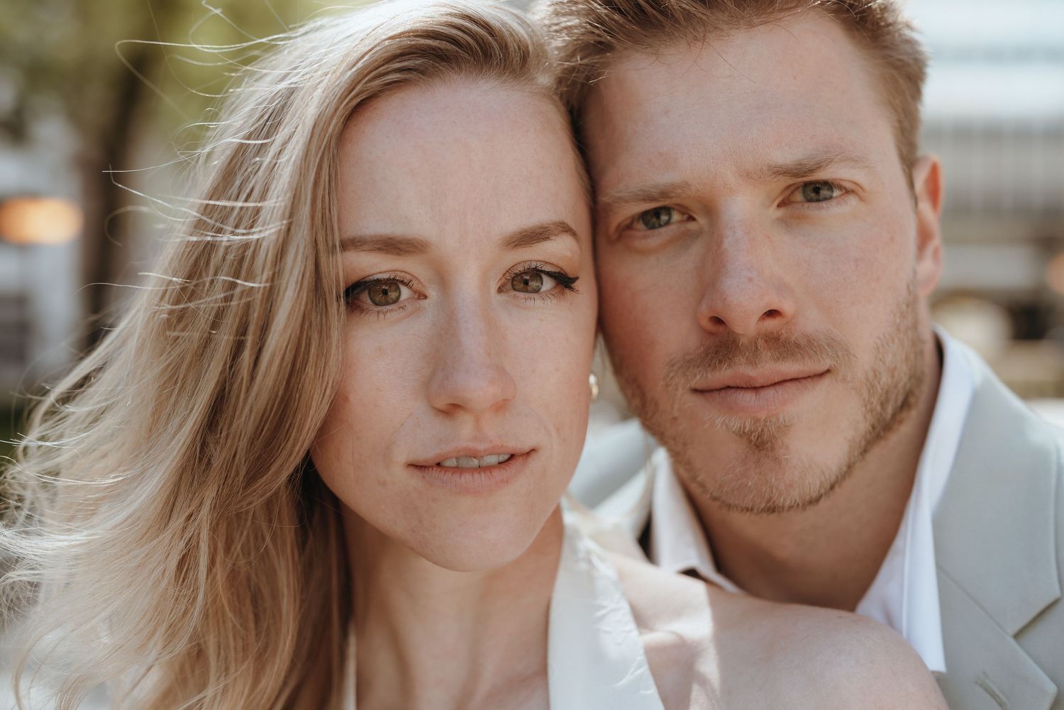 Close-up portrait of a smiling bride and groom on their wedding day outdoors.