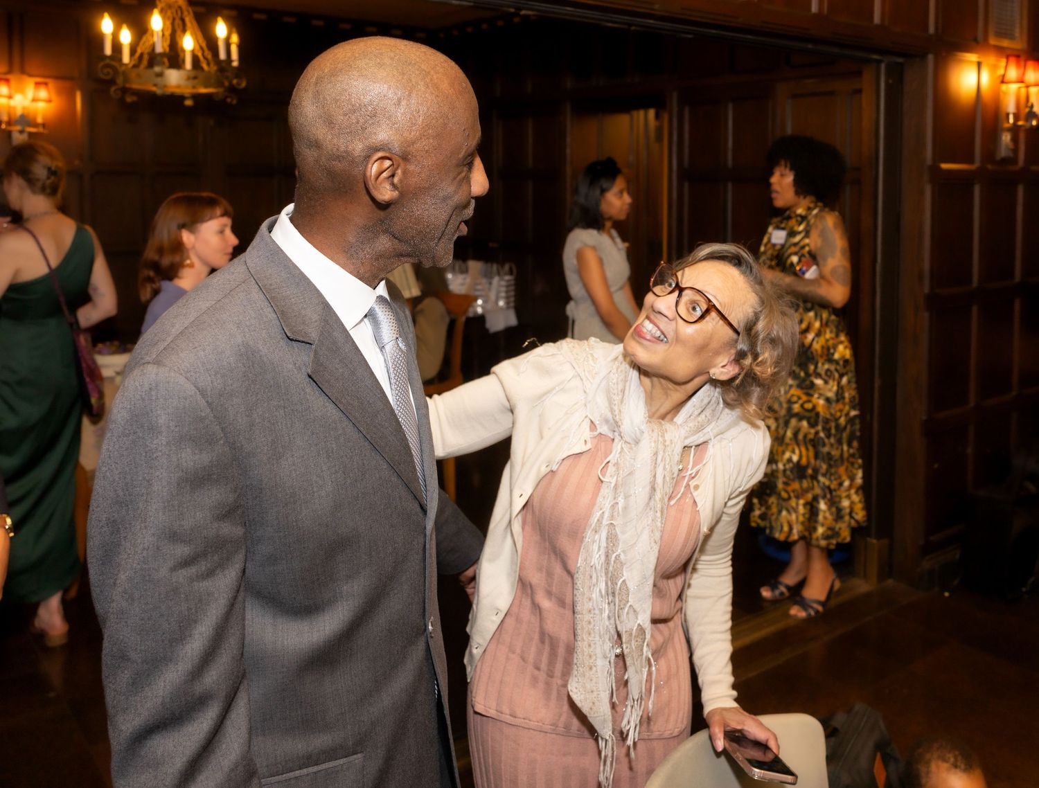Man and woman share a warm conversation at an upscale evening social reception event.