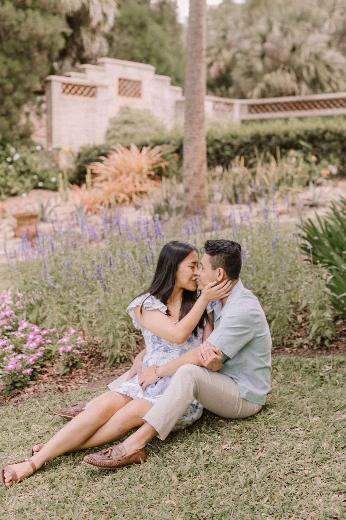 Romantic couple sharing an intimate moment in a blooming garden with lavender flowers.