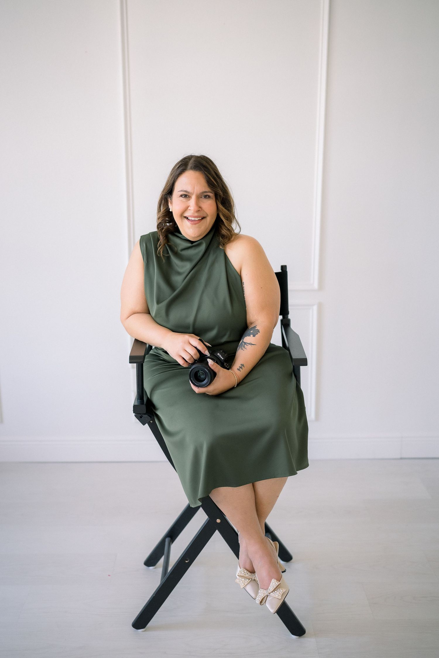 A person in a green dress poses on a black director's chair in a white studio space across multiple shots.