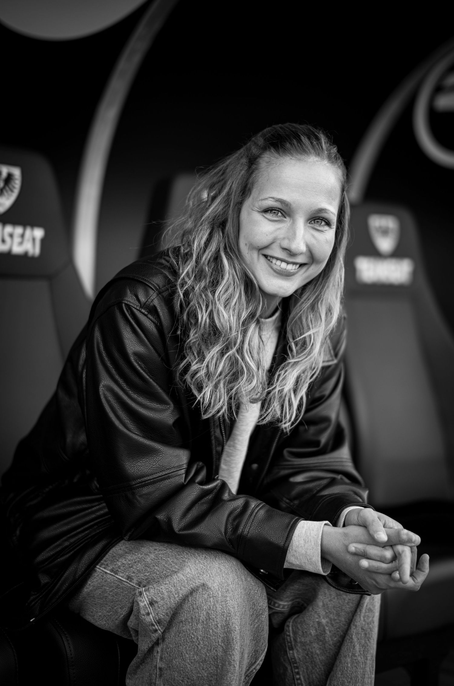 Black and white photo series showing a person in dark clothing sitting and smiling on a bench.