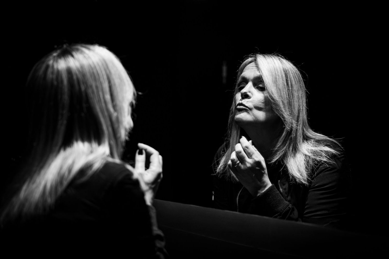 A dramatic black and white photo collage shows silhouetted profiles and reflections against a dark background.