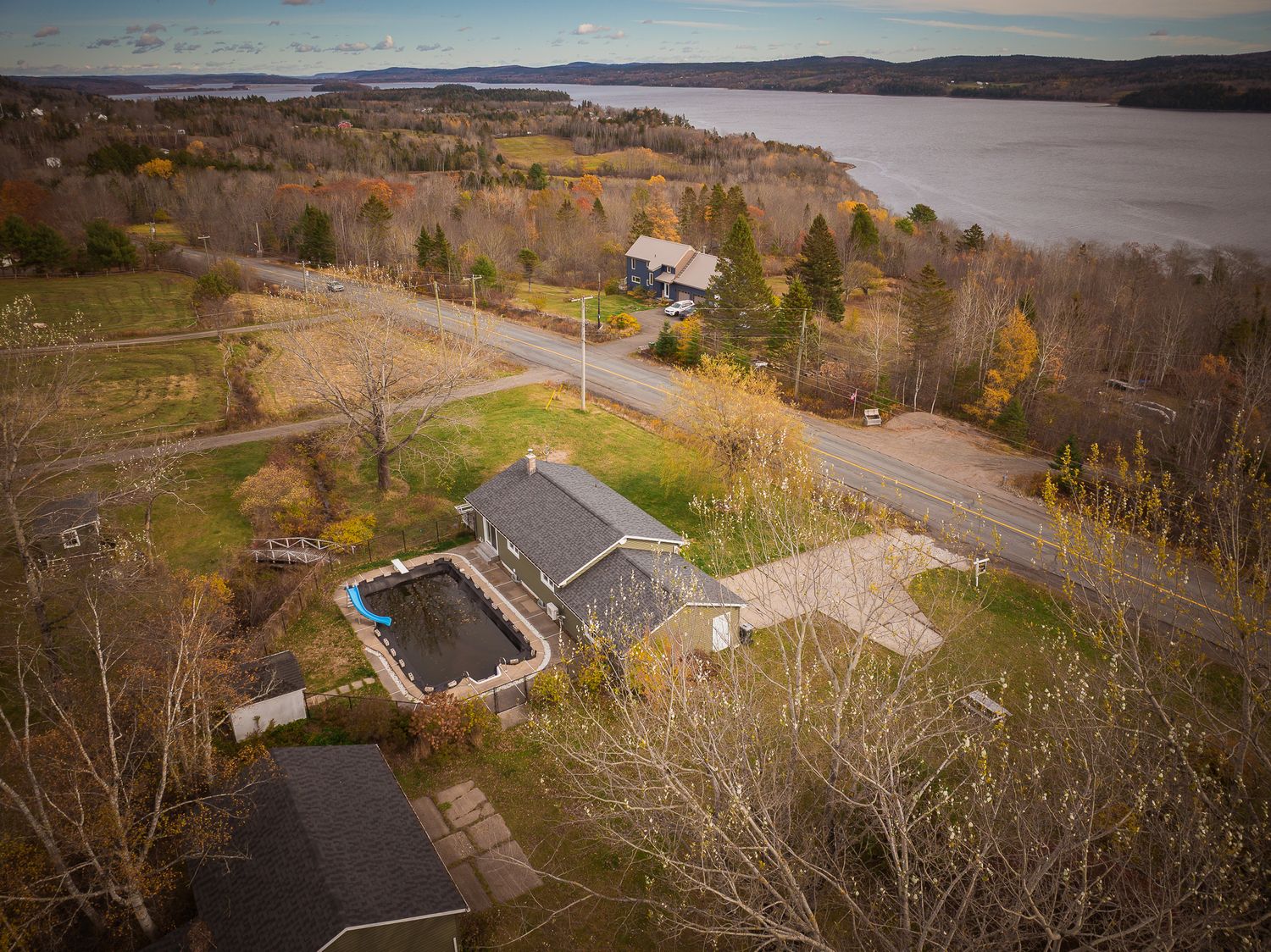 Panoramic aerial view of a rural landscape with autumn foliage, winding roads, and scattered buildings in the valley near Saint John.