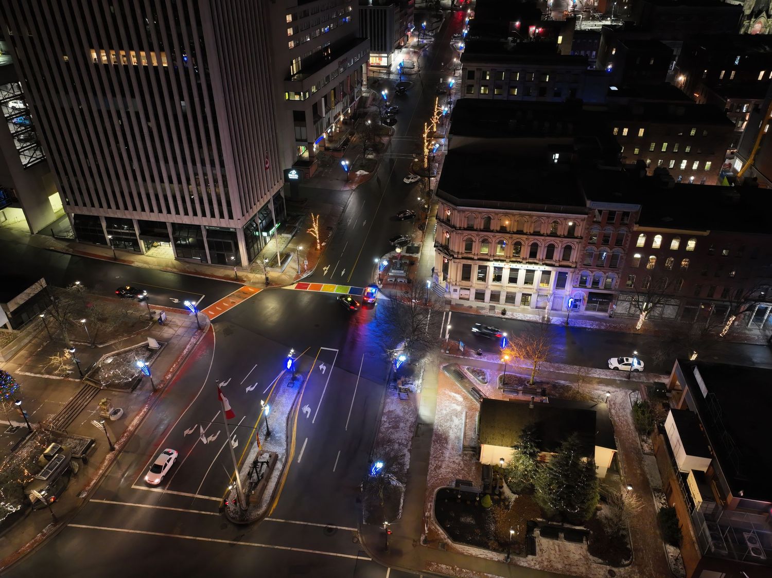 Aerial view of city streets at night with colorful lights and traffic patterns, lower King St in Saint John, NB.