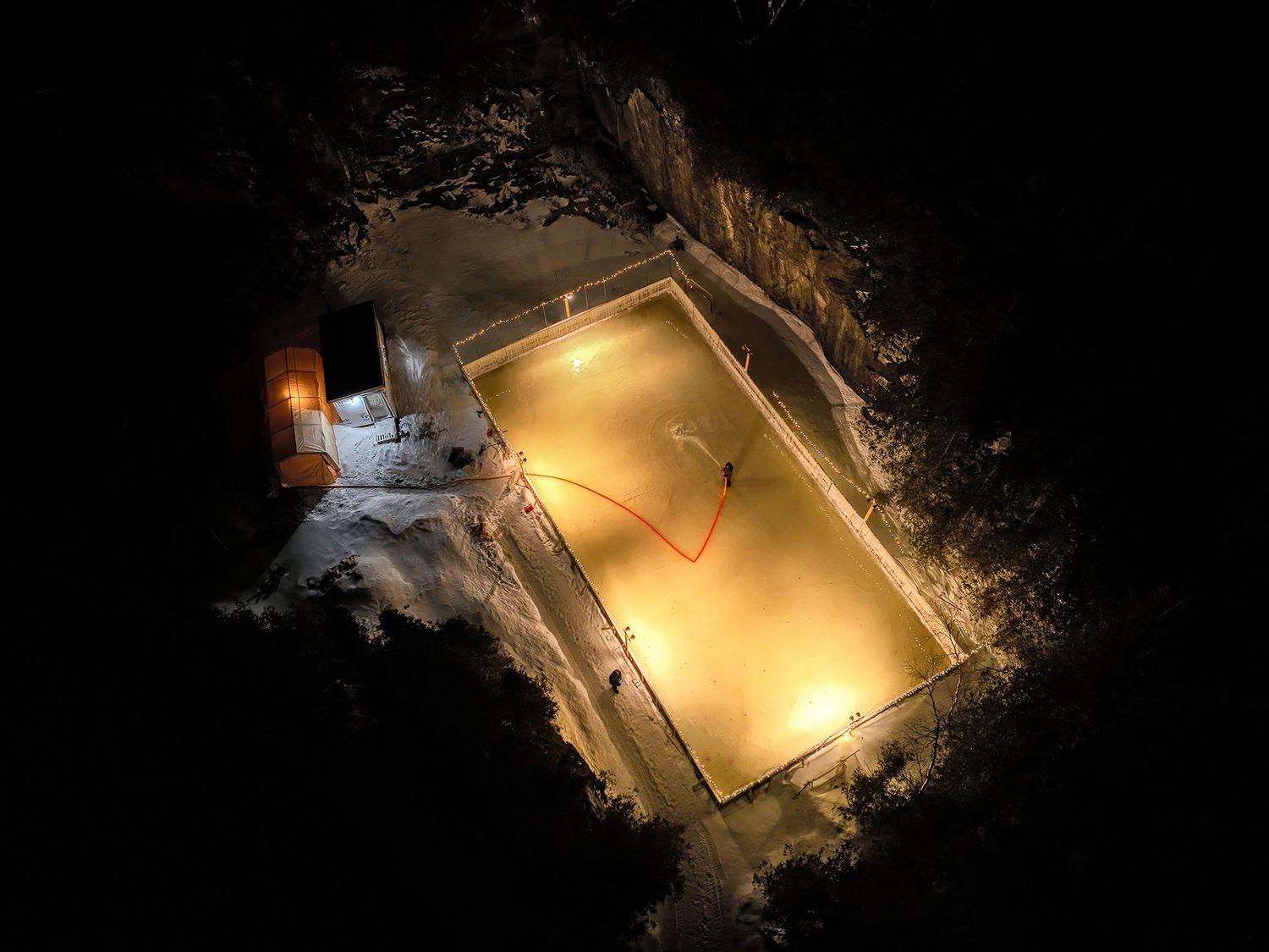 Aerial night view of illuminated hockey ring glowing in darkness in New Brunswick.