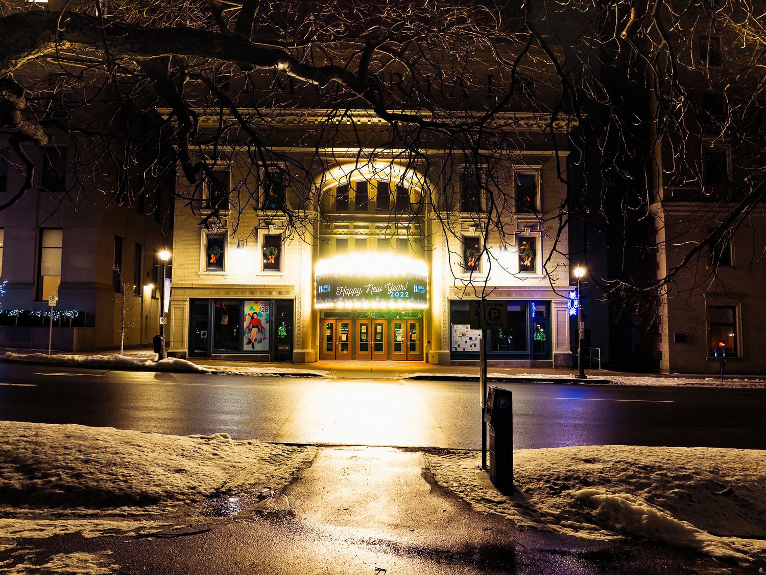 Imperial Theatre in Saint John, illuminated at night with warm glowing lights creating a cozy winter atmosphere.