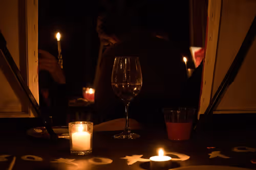 a deliberately contrasty picture of wine classes and candles.  The candle is reflecting off the wine class at a gallery event in Saint John