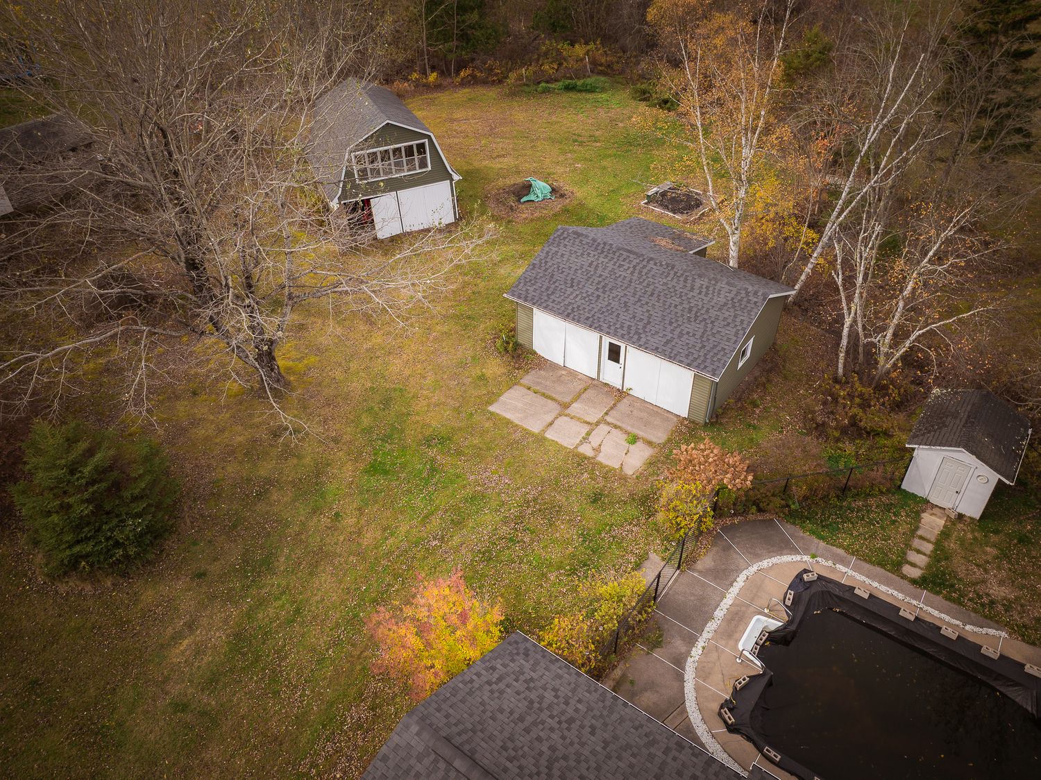 Aerial drone panorama of a rural residential property with autumn trees and multiple buildings in the countryside near Saint John.