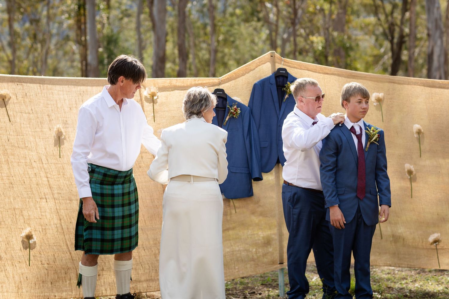 Wedding ceremony setup in a natural outdoor setting with wooden benches and decor.