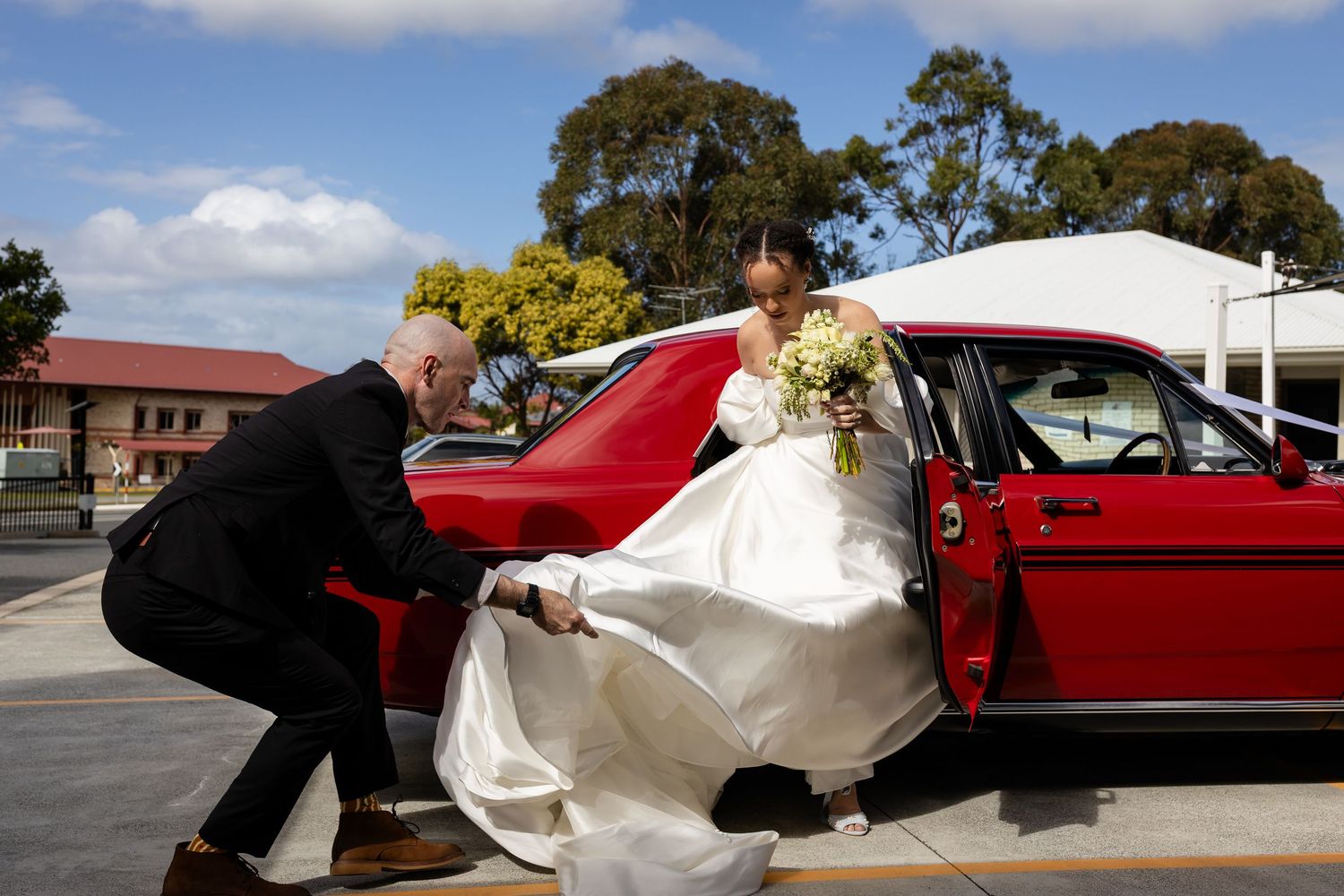 A classic red car parked outside serves as a wedding day photo backdrop.Gold Coast hinterland wedding photographer