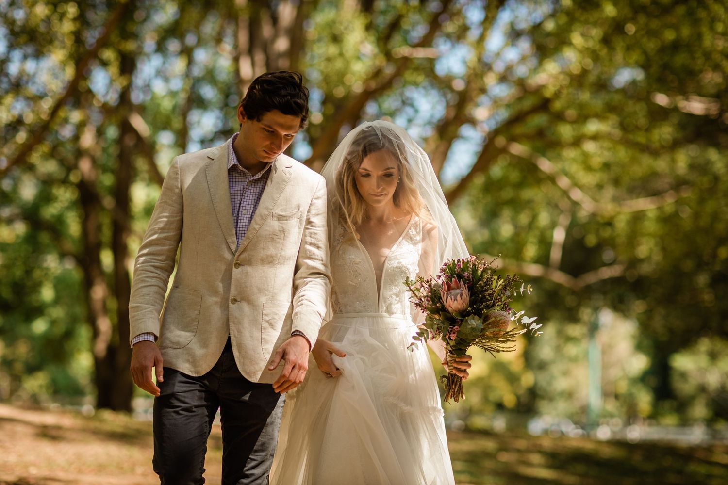 Wedding couple stands together under trees during an intimate forest ceremony.Currumbin Valley wedding photography Gold Coast