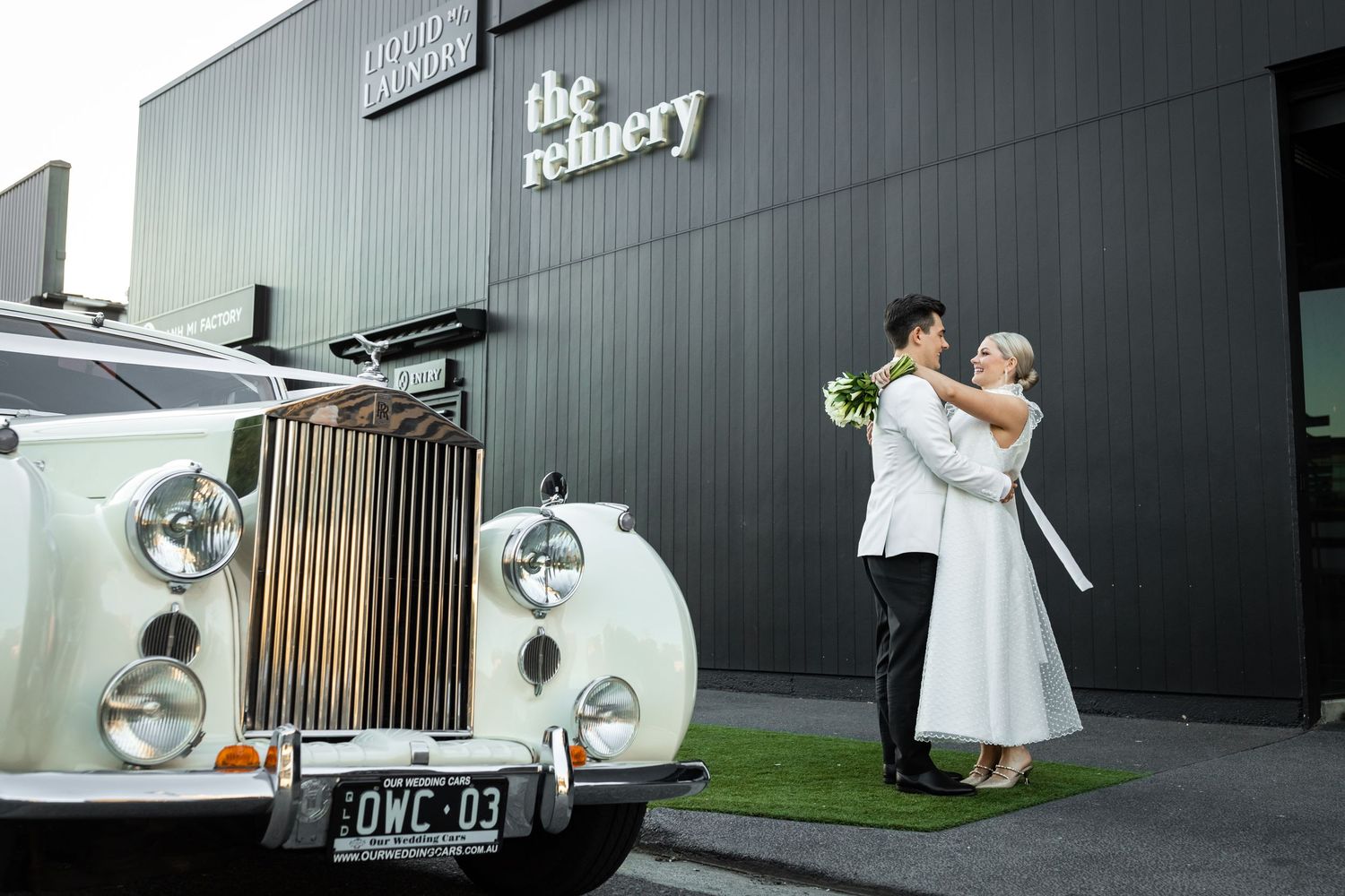 Modern wedding photography session outside industrial building with vintage car.The refinery wedding venue. Brisbane.
