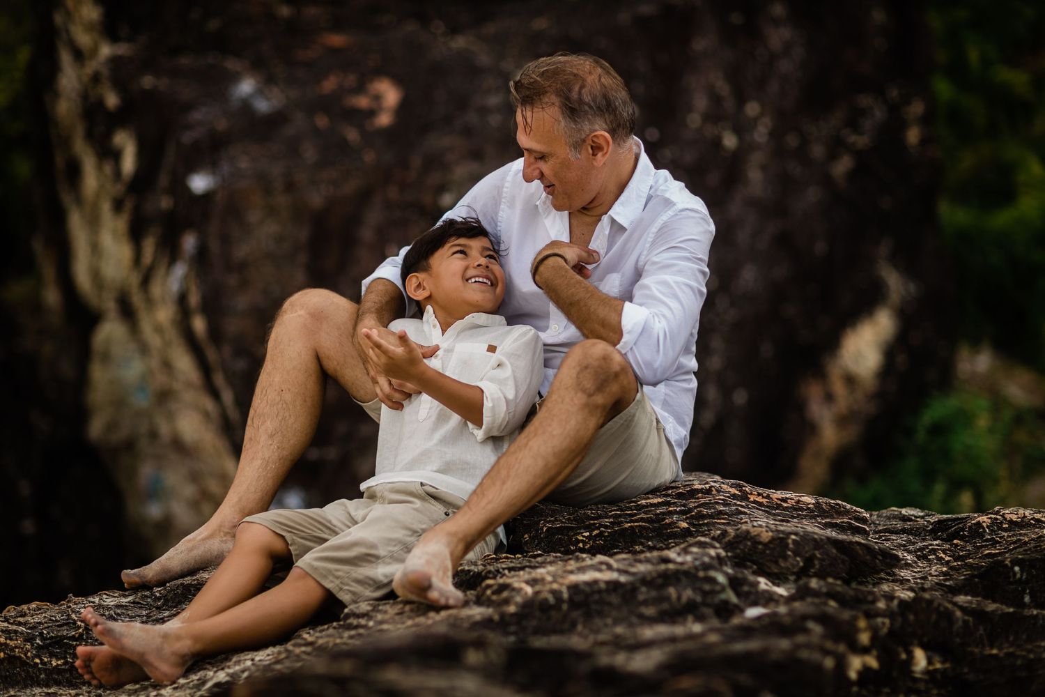 Intimate family moments captured on a rustic log in natural outdoor setting.Gold Coast candid family photographer.