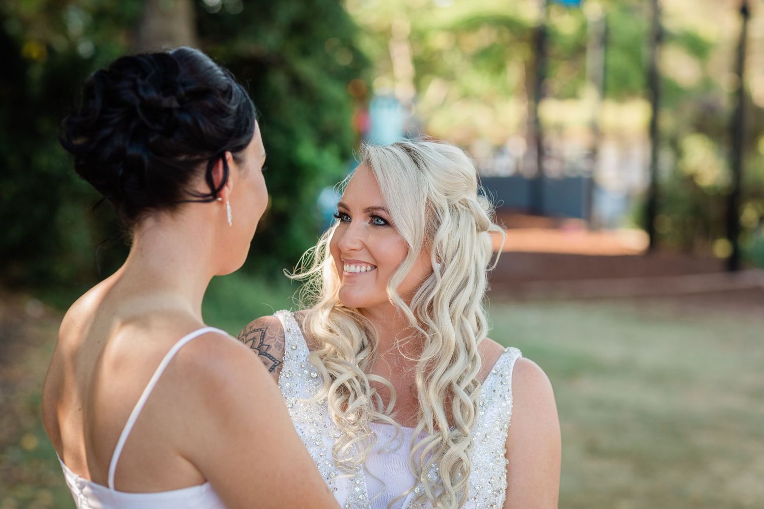 Two people share a tender moment during their wedding photoshoot in a garden setting.candid wedding photography Gold Coast