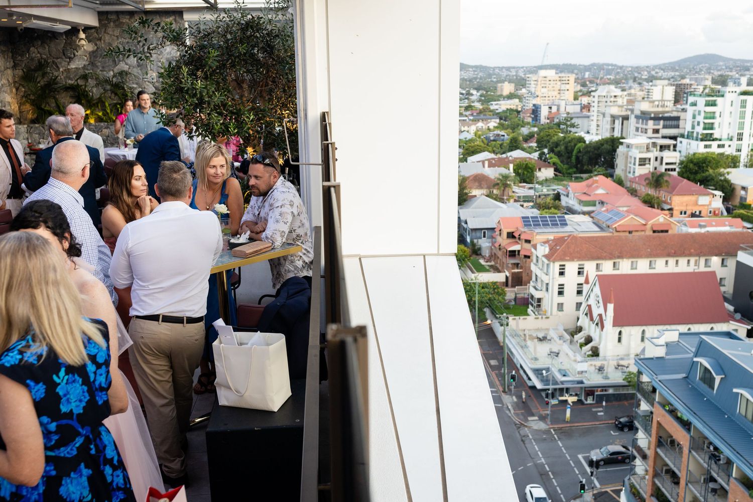Guests enjoying a rooftop wedding reception with urban views in the background. Brisbane wedding venue