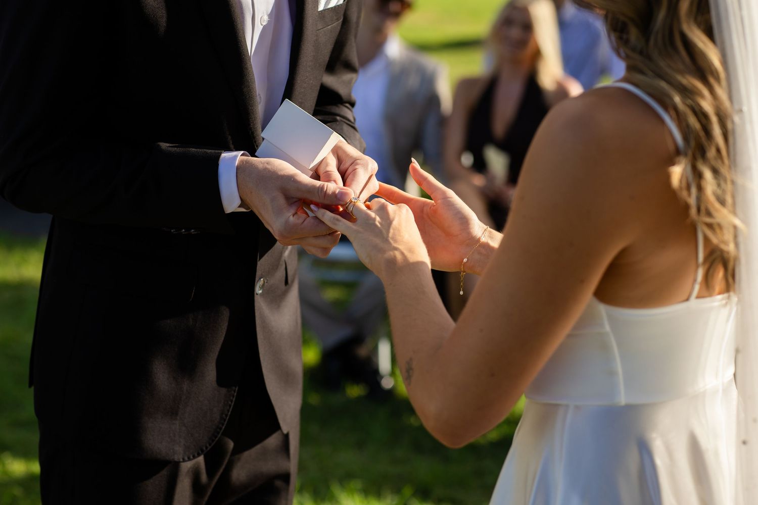 Wedding ceremony attendees holding program booklets during outdoor service.beach wedding currumbin surf club wedding