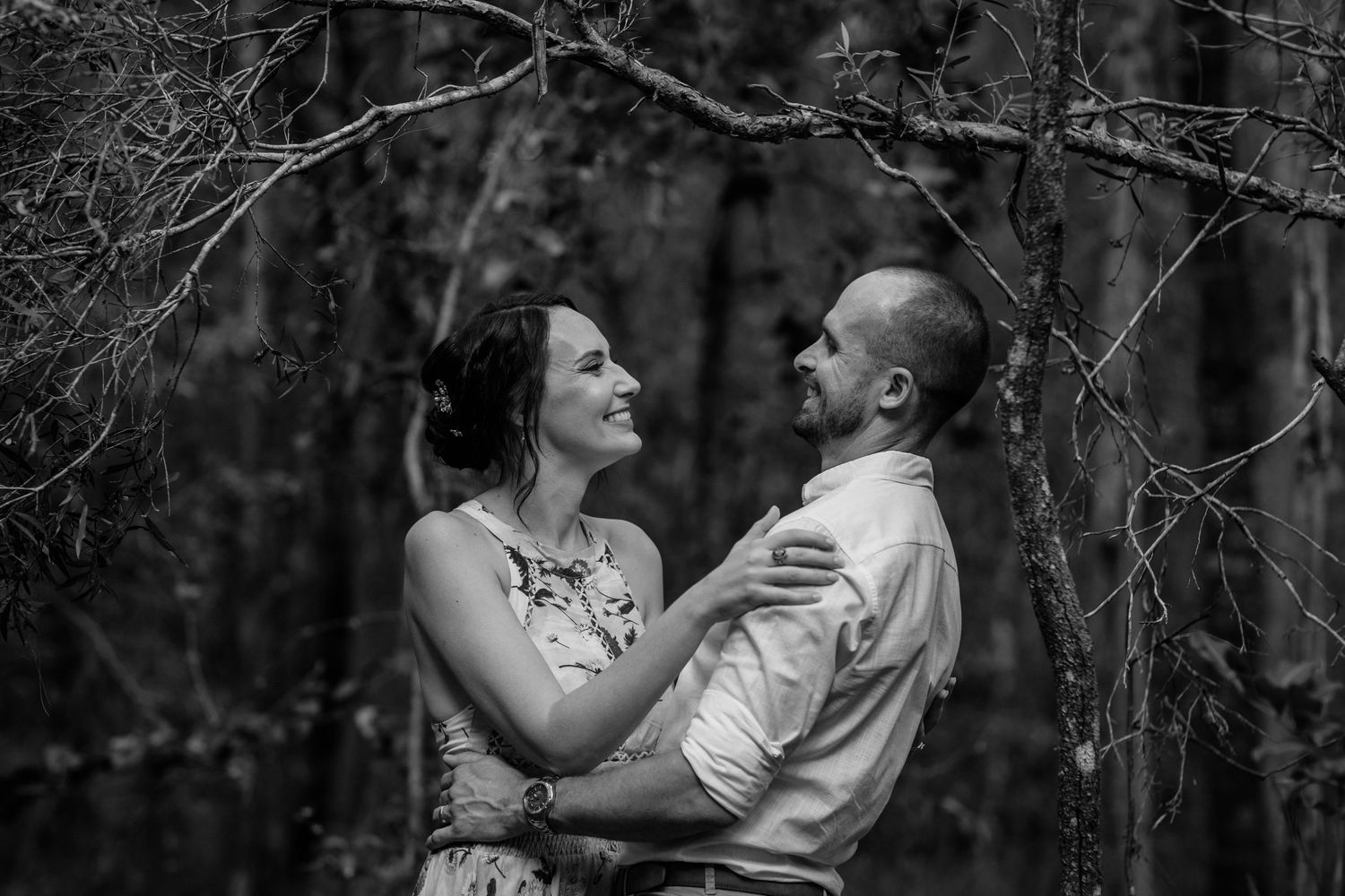 A romantic black and white photograph captures an intimate dance-like moment in the woods.Gold Coast elopement photographer