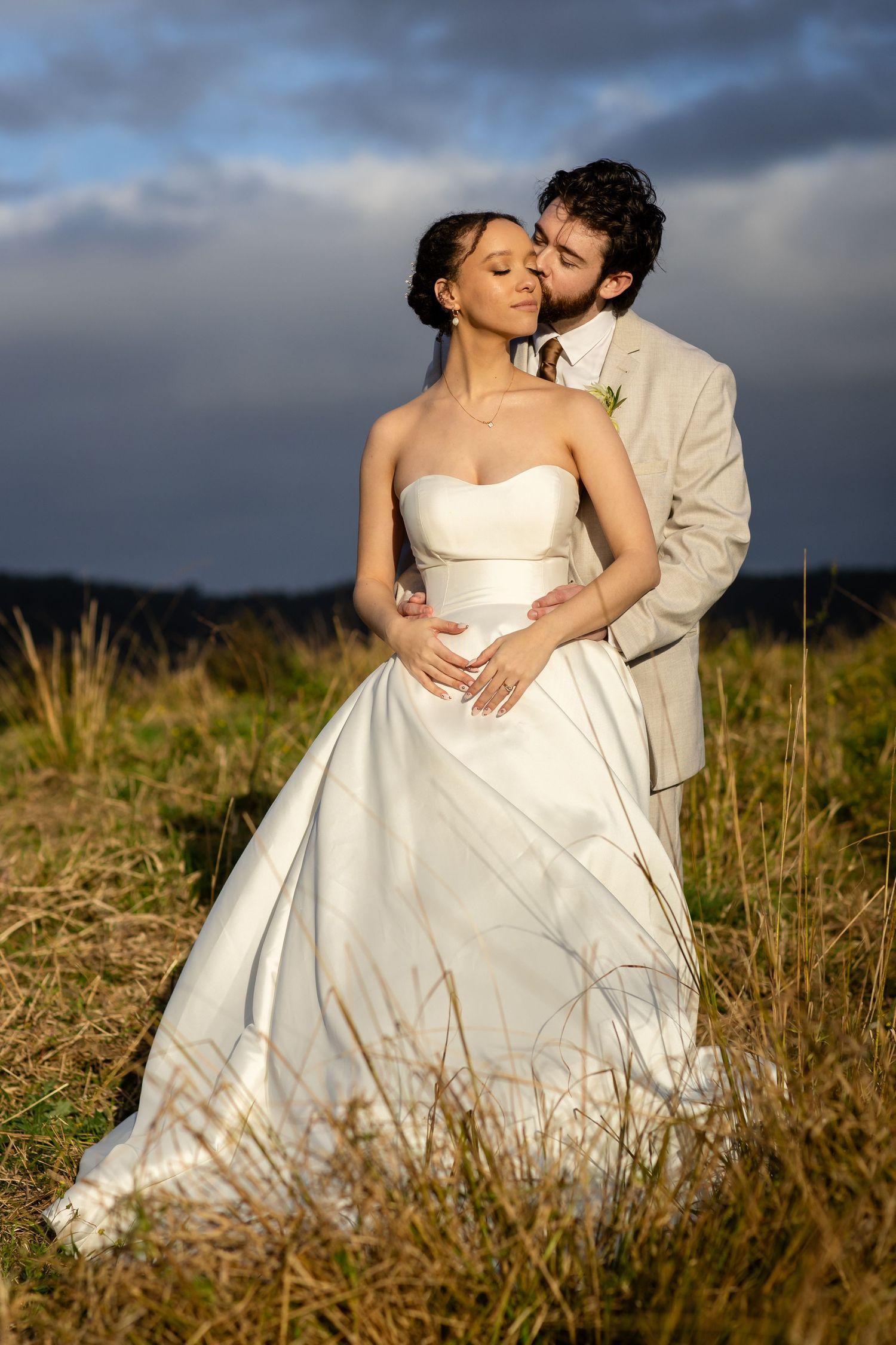 Romantic wedding portraits in golden light amidst tall grass and natural landscape.The barrow restaurant mount Nathan wedding