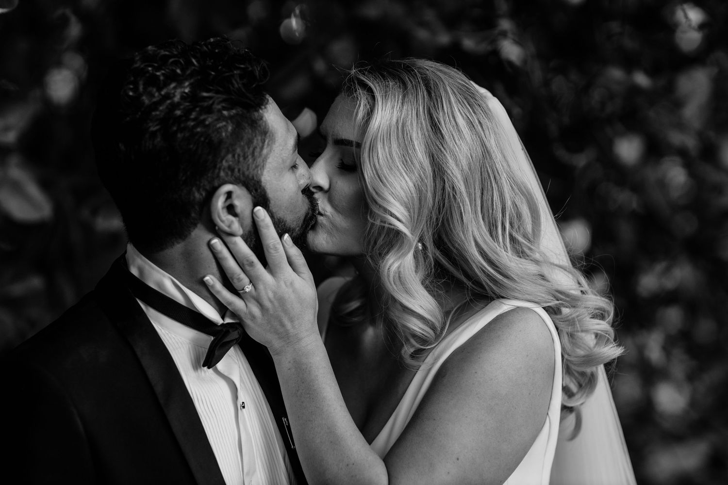 An intimate black and white portrait of a couple sharing a romantic moment.