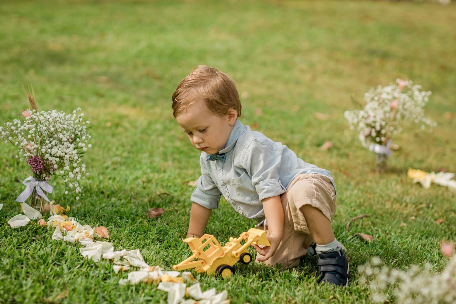 Young child exploring and playing in grass during a wedding event.Gold Coast beach wedding photography