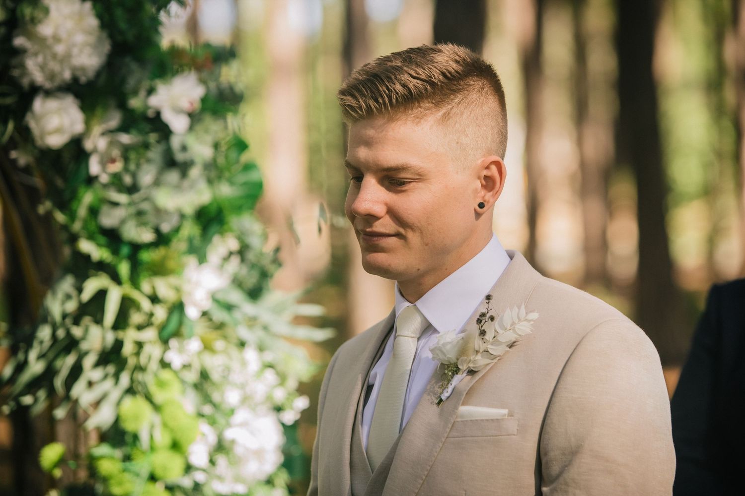 Groomsmen in light beige suits standing among tall trees at a forest wedding.pizzey park wedding Gold Coast