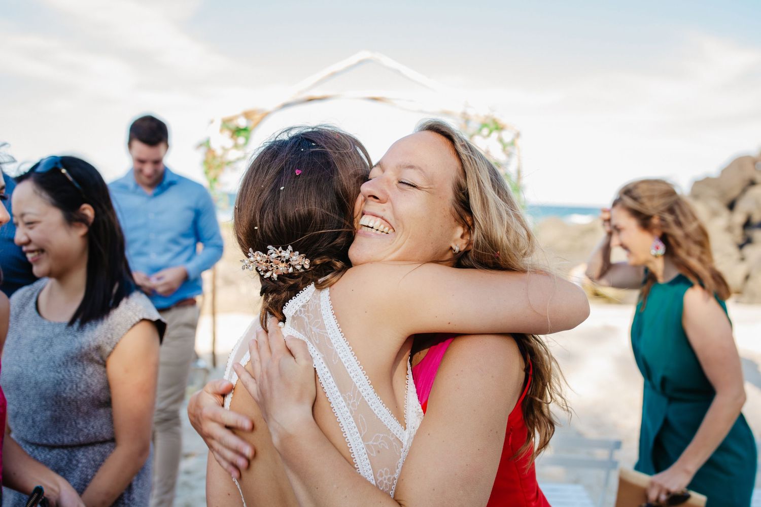 Wedding guests celebrating on sunny beach with ocean in background.Gold Coast beach wedding photography. Froggies beach