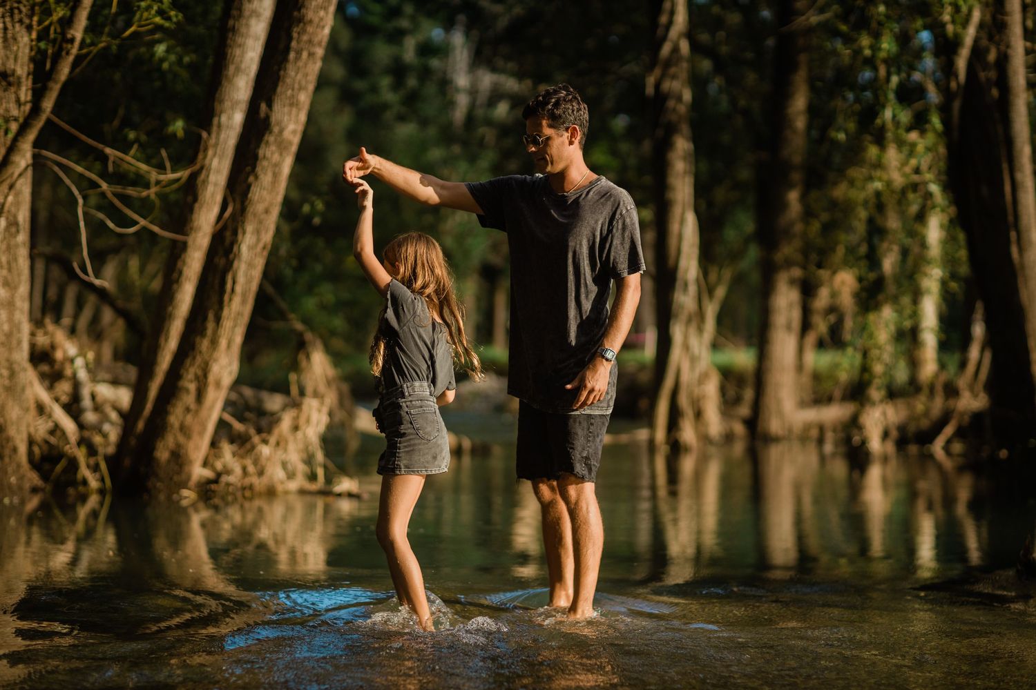 Children playing and splashing in a shallow wooded creek on a sunny summer day. Gold Coast family photographerGold Coast candid family photo