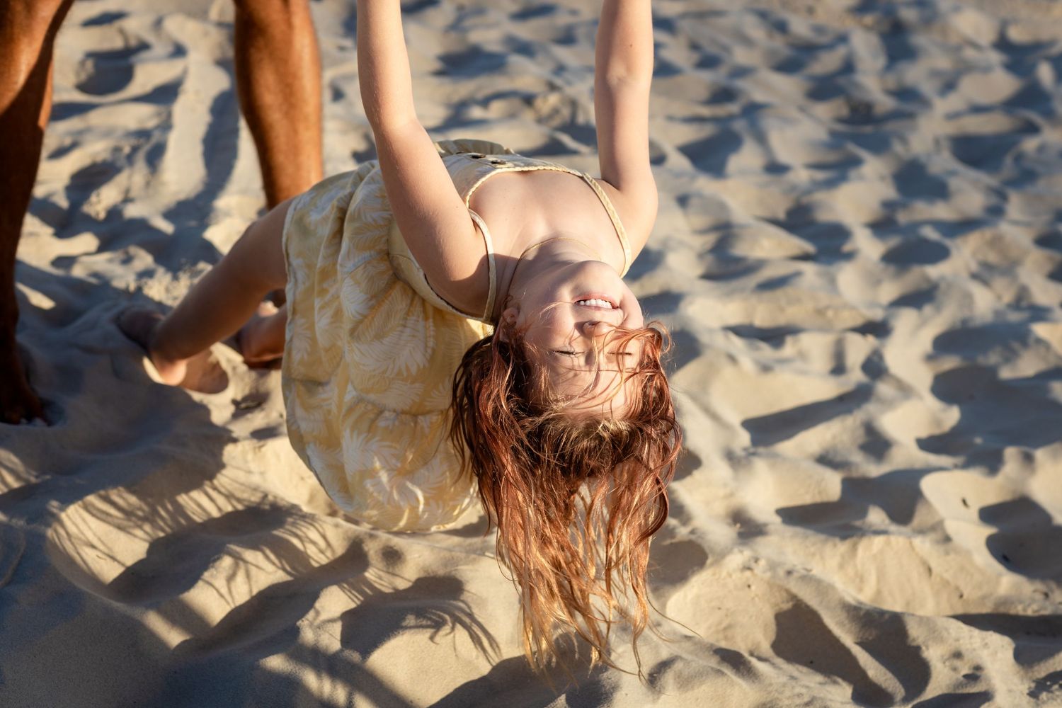 People playing and having fun in the sand at sunset.Gold Coast candid family photographer.