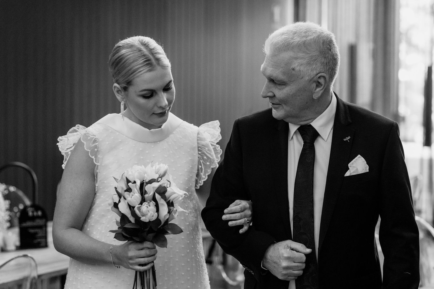 Black and white photo of wedding ceremony moments indoors.