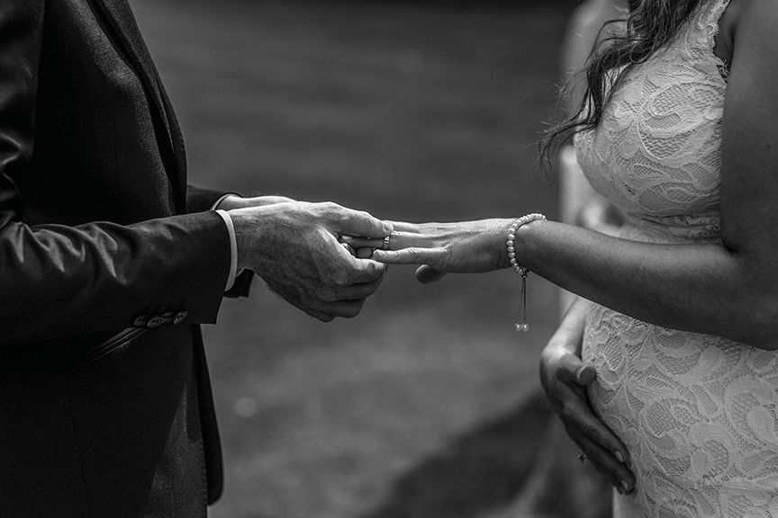 Black and white photos of hands exchanging rings during a wedding ceremony.candid wedding photography Gold Coast