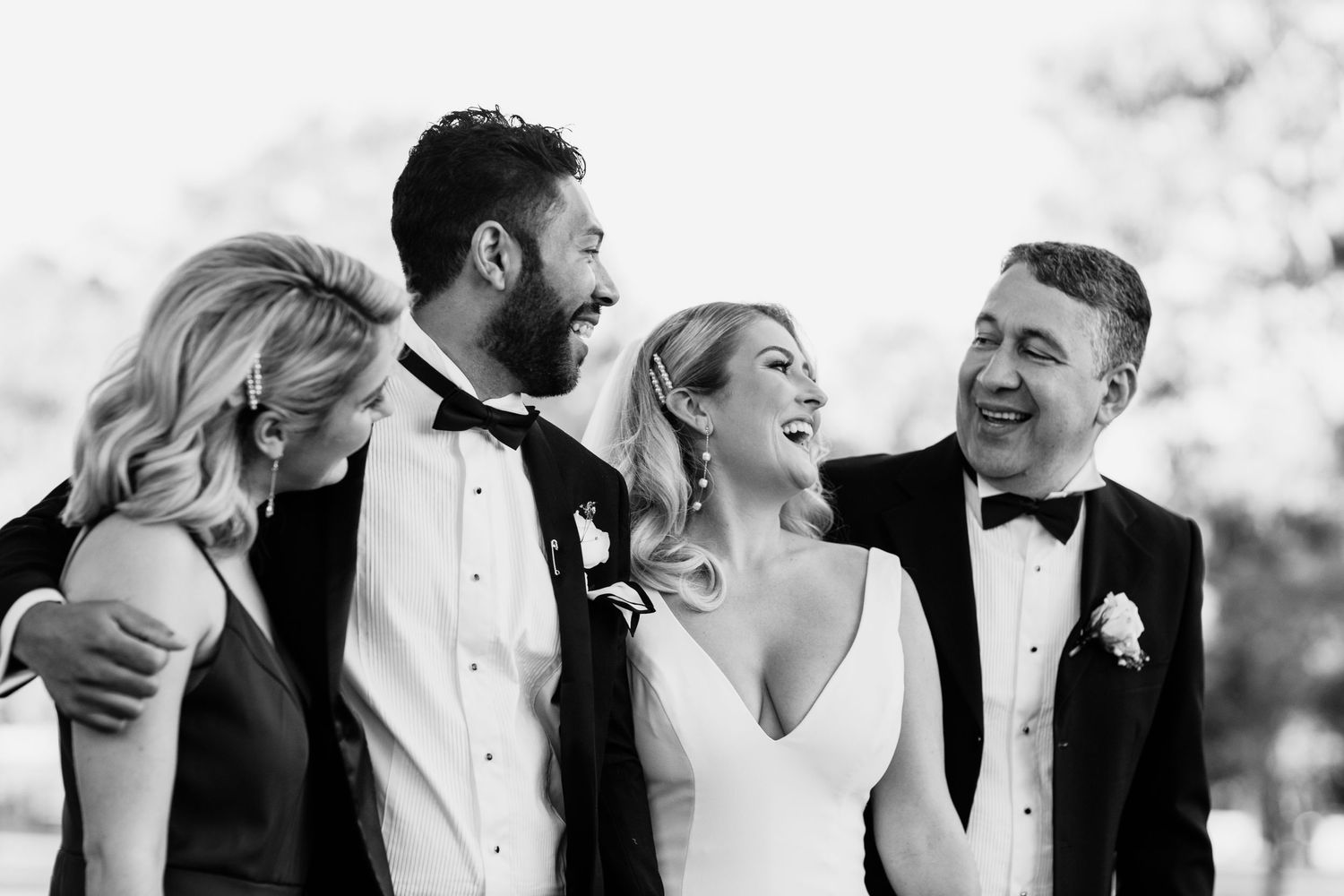 A black and white photo series showing joyful wedding party members laughing together outdoors. Surfers Paradise Golf Club wedding.