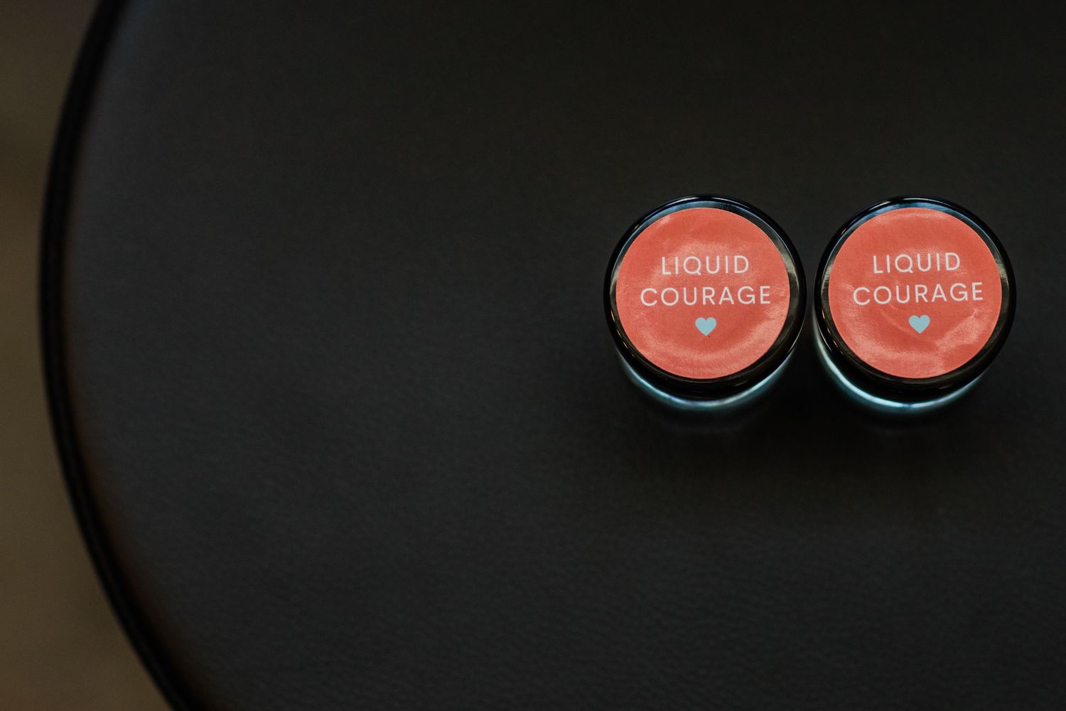 Circular seating cards with pink accents arranged for wedding guests.