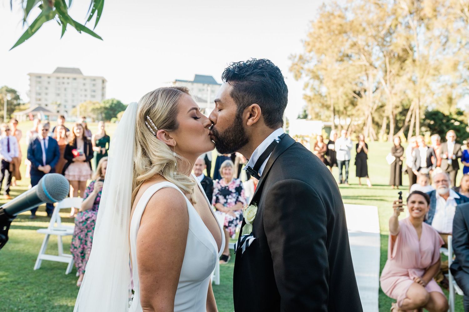 A joyful moment captured between newlyweds during their outdoor garden wedding celebration. Surfers Paradise Golf Club wedding.