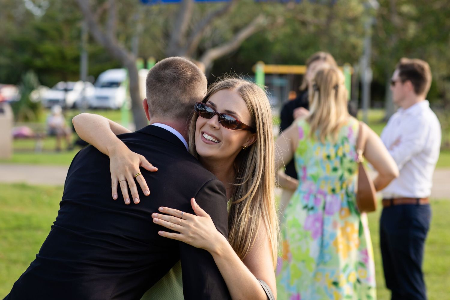 Wedding party members share joyful moments during outdoor photo session.