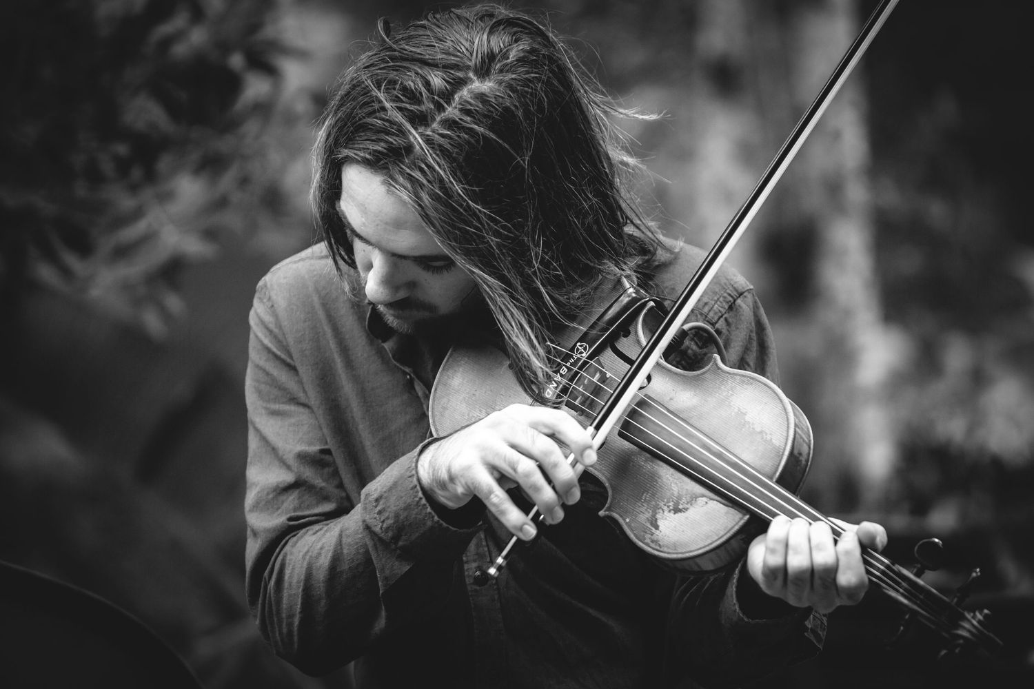 Musicians performing with violins in black and white artistic photography.