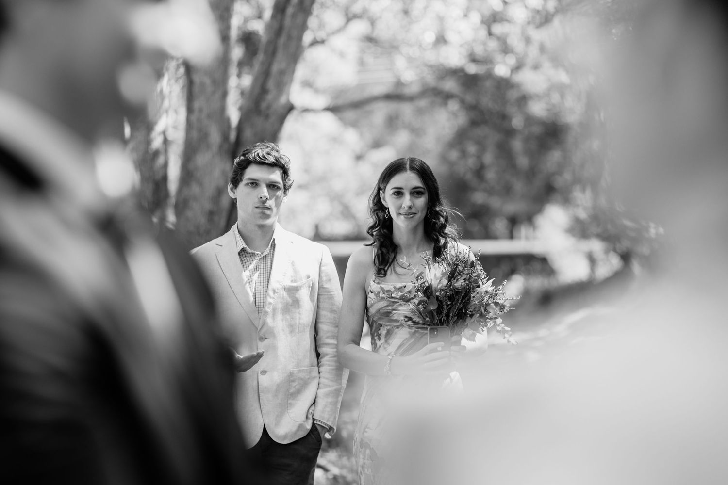Black and white photo of a couple during an outdoor wedding ceremony in a natural setting.Currumbin Valley wedding photography Gold Coast