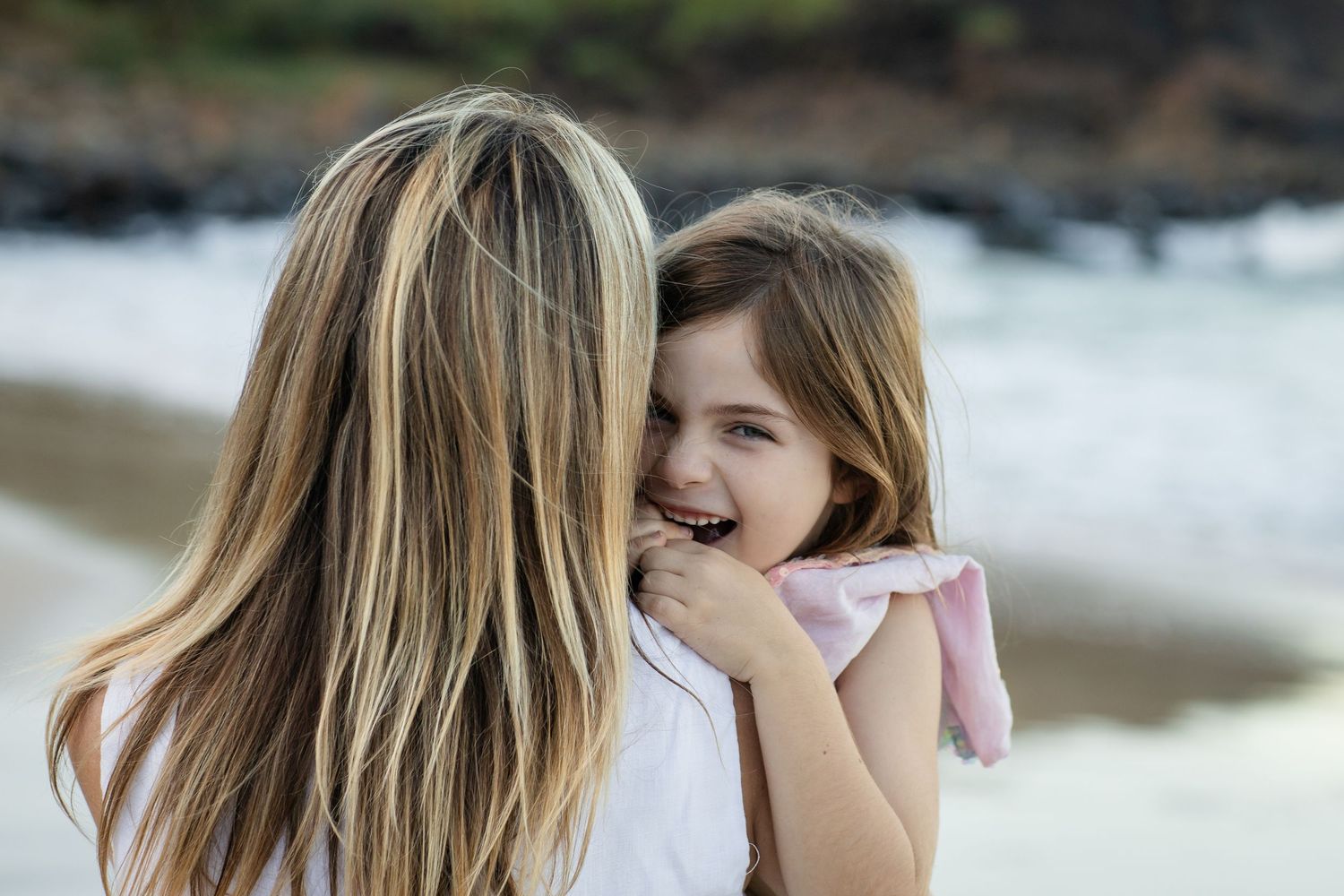 People sharing intimate moments and embraces at a beach setting during golden hour.Gold Coast candid family photographer. Cabarita headland