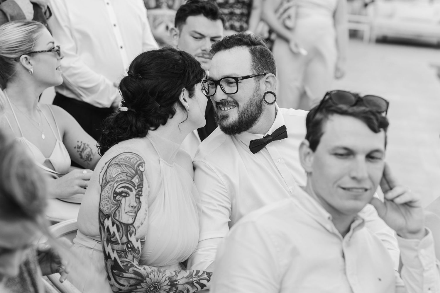 Wedding guests enjoy candid moments during outdoor reception celebration.