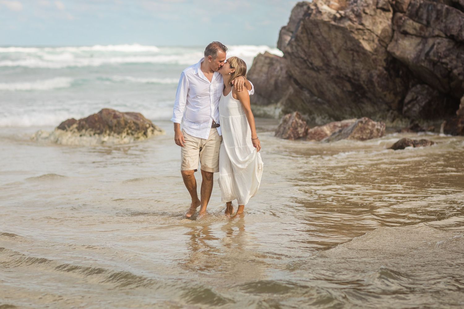 Family exploring rocky beach shoreline during sunset.Gold Coast candid family photographer.