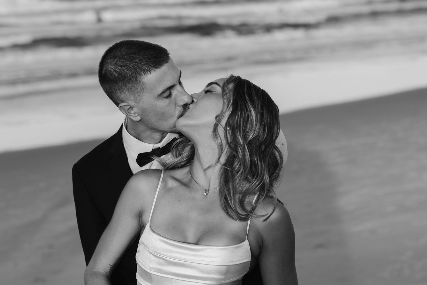 A black and white beach portrait of newlyweds sharing an intimate moment. Tugun beach wedding Currumbin beach wedding