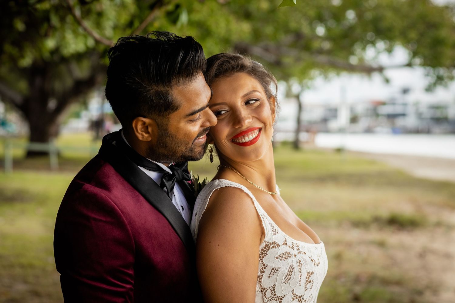 A romantic couple shares tender moments in a garden setting during their wedding photoshoot.