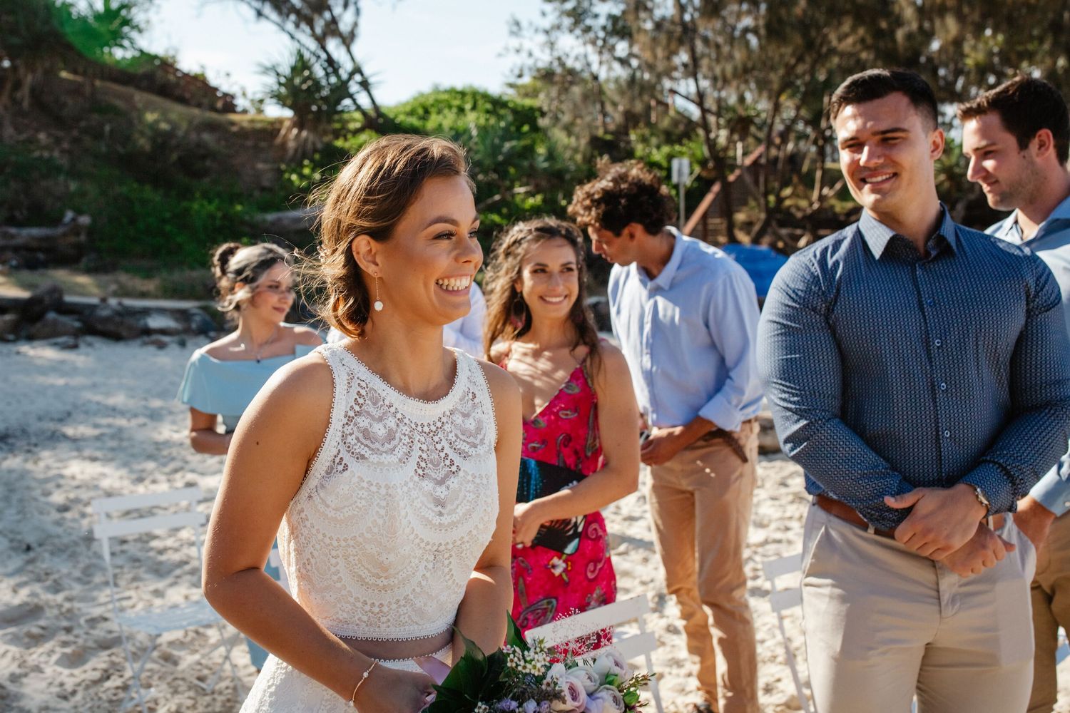 Wedding guests gathered at an intimate outdoor beach ceremony.